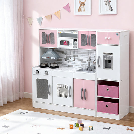 Children's play kitchen set with pink and white cabinets in a room with pink walls and toys on the floor.