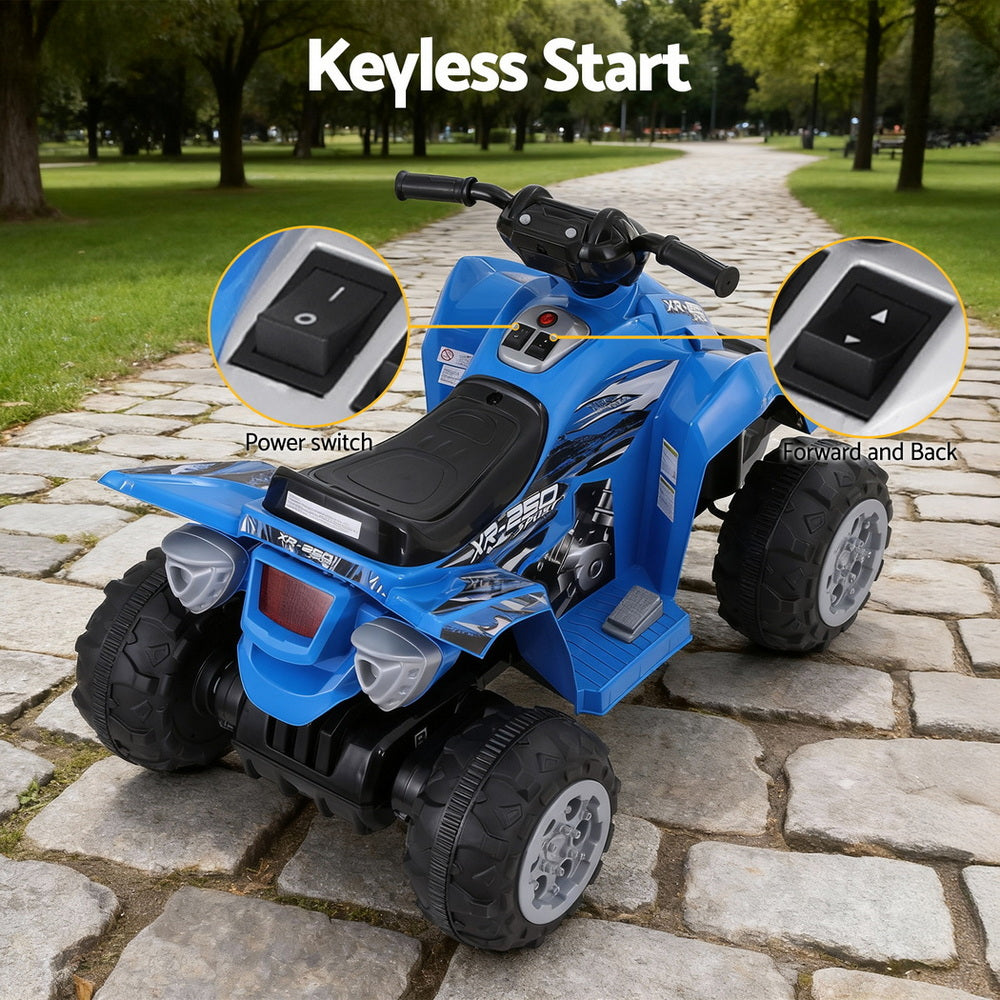 Blue toy ATV with keyless start feature on a stone path in a park.