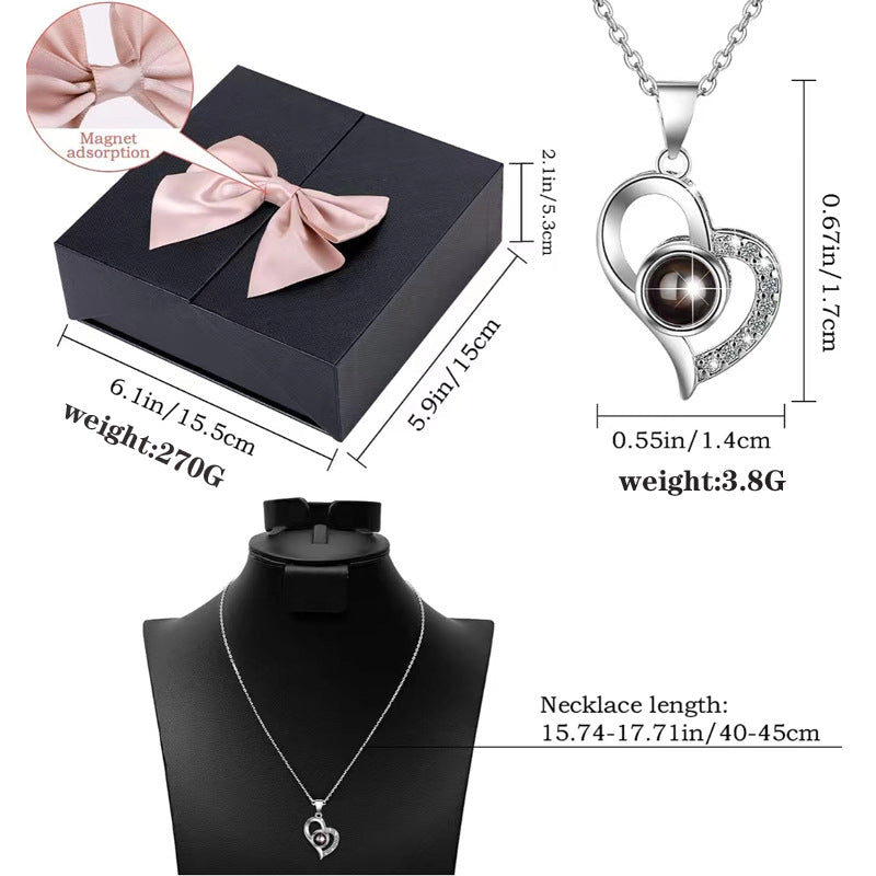 Platinum heart-shaped projection necklace, engraved with 100 ways to say "I love you," paired with matching heart-shaped earrings, presented in a rose-adorned double-door gift box—a refined gift blending technology and romance.