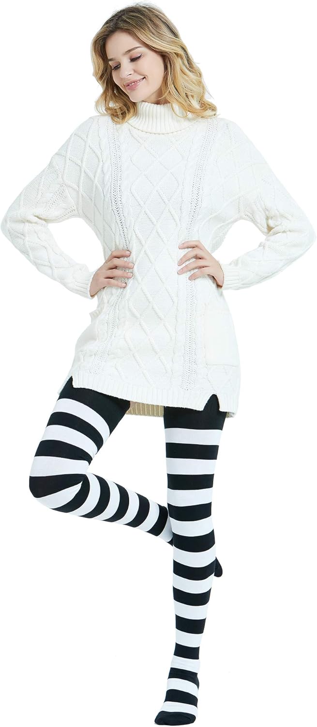 Woman wearing a white cable knit sweater and black and white striped leggings on a white background
