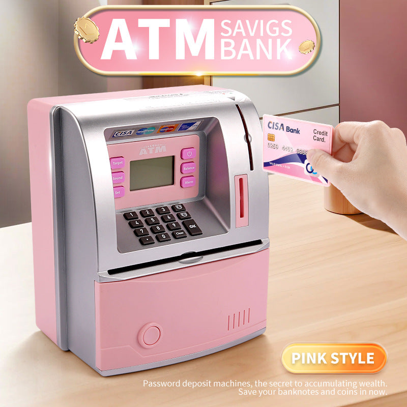 Pink toy ATM savings bank with a hand inserting a card, on a wooden surface.